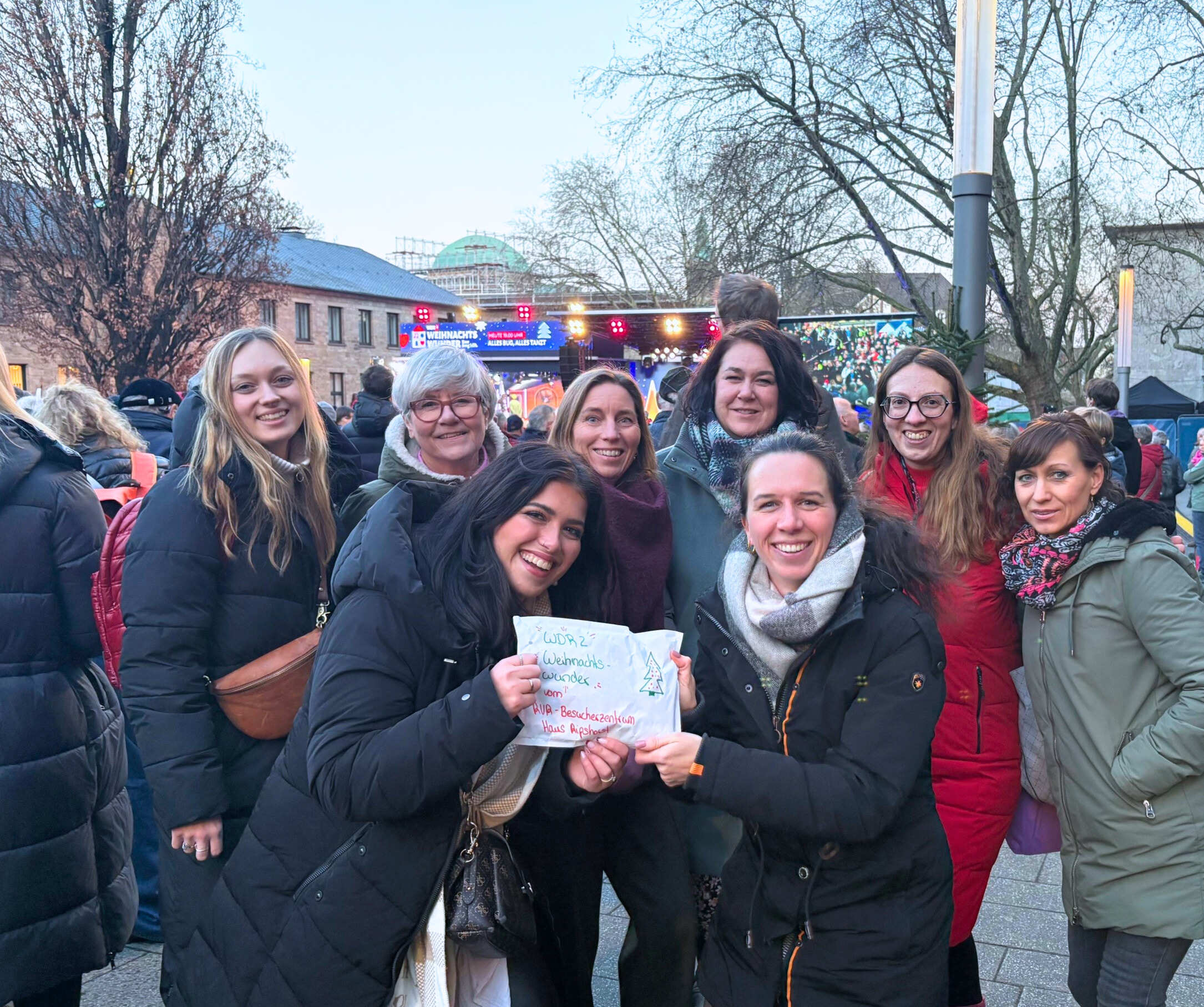 Acht Frauen stehen auf dem Burgplatz in Essen mit einem Umschlag mit Spendengeldern.